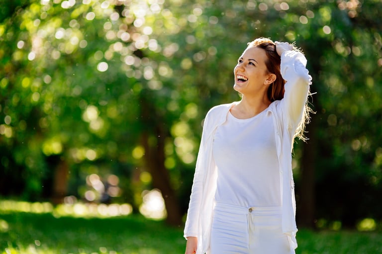 Beautiful woman in nature enjoying good weather, feeling peaceful and free