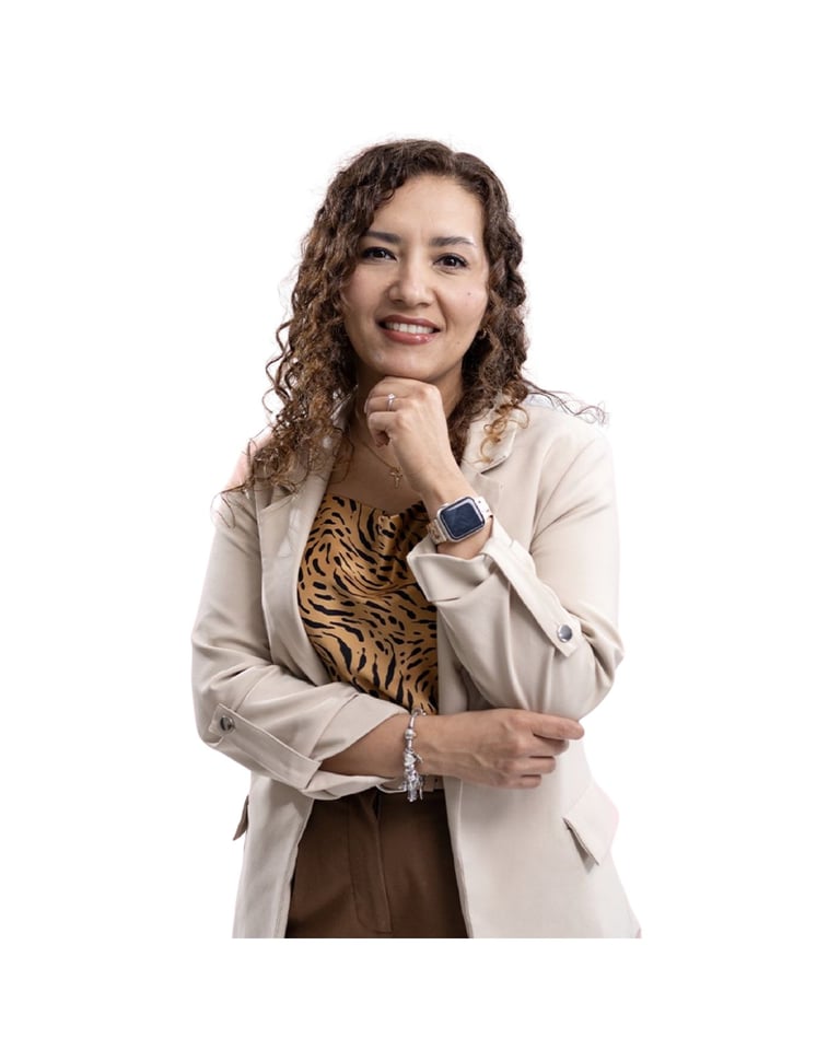 Woman with curly brown hair wearing a beige blazer and tiger-print shirt, smiling with hand near face against white background